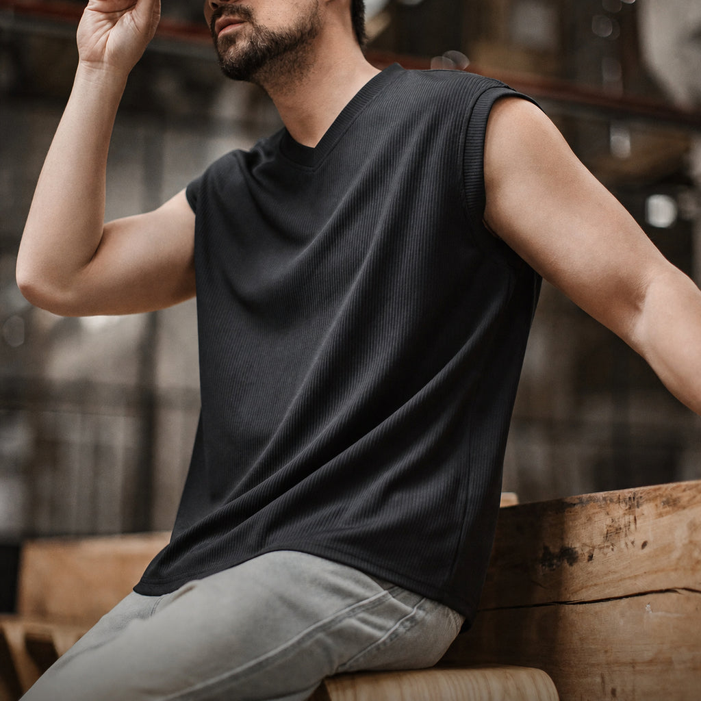 Man in the black ribbed v-neck tank, seated pose