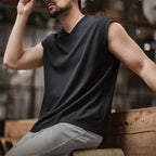 Man in the black ribbed v-neck tank, seated pose