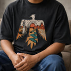 Seated man wearing the washed black thunderbird tee with blue jeans