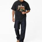 Man wearing the washed black thunderbird tee with dark jeans, full view