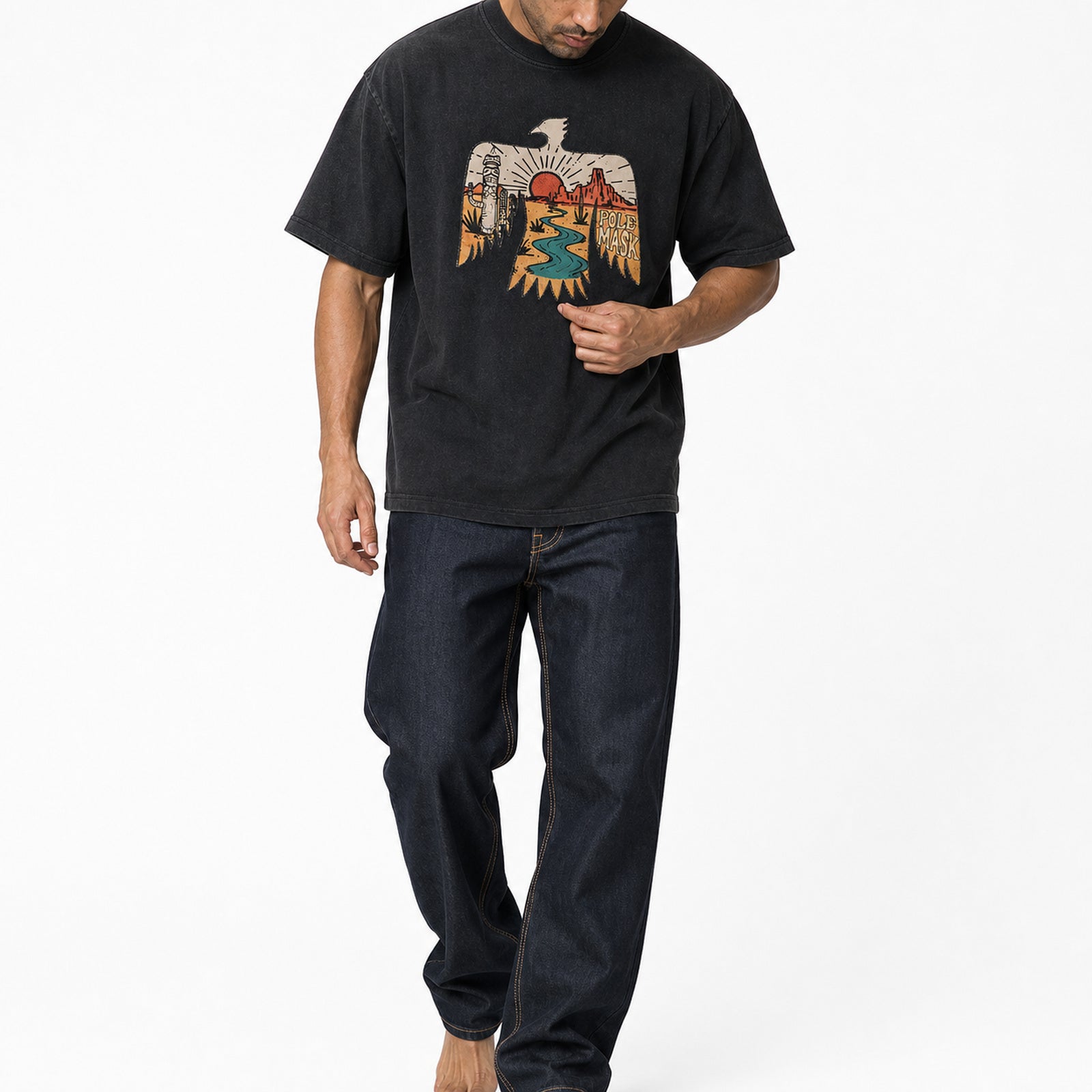 Man wearing the washed black thunderbird tee with dark jeans, full view