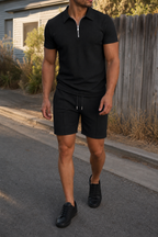 Man wearing the black waffle knit zip collar polo set, suburban outdoor setting