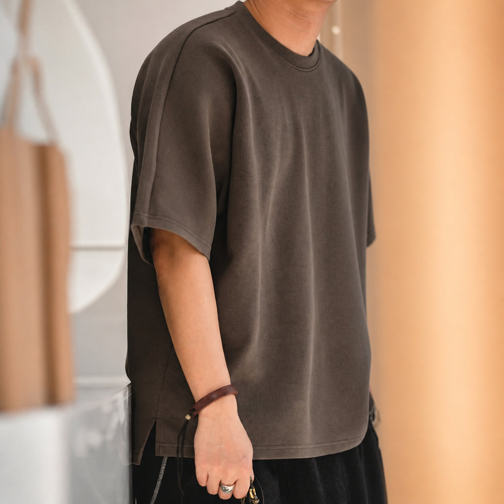Man wearing the coffee brown oversized boxy tee, side view