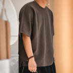 Man wearing the coffee brown oversized boxy tee, side view