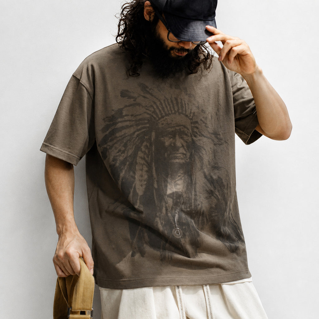 Man wearing the coffee chief portrait tee layered over a white tee with cream trousers