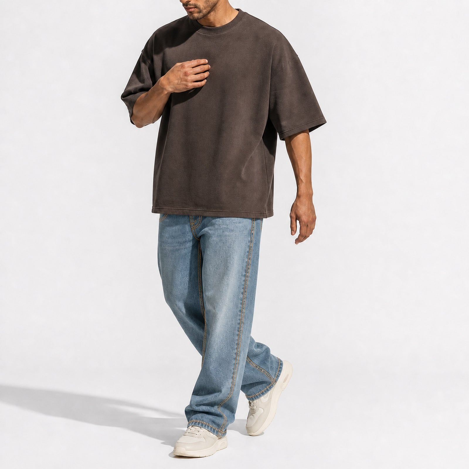 Man wearing the coffee brown oversized boxy tee with light jeans, full view