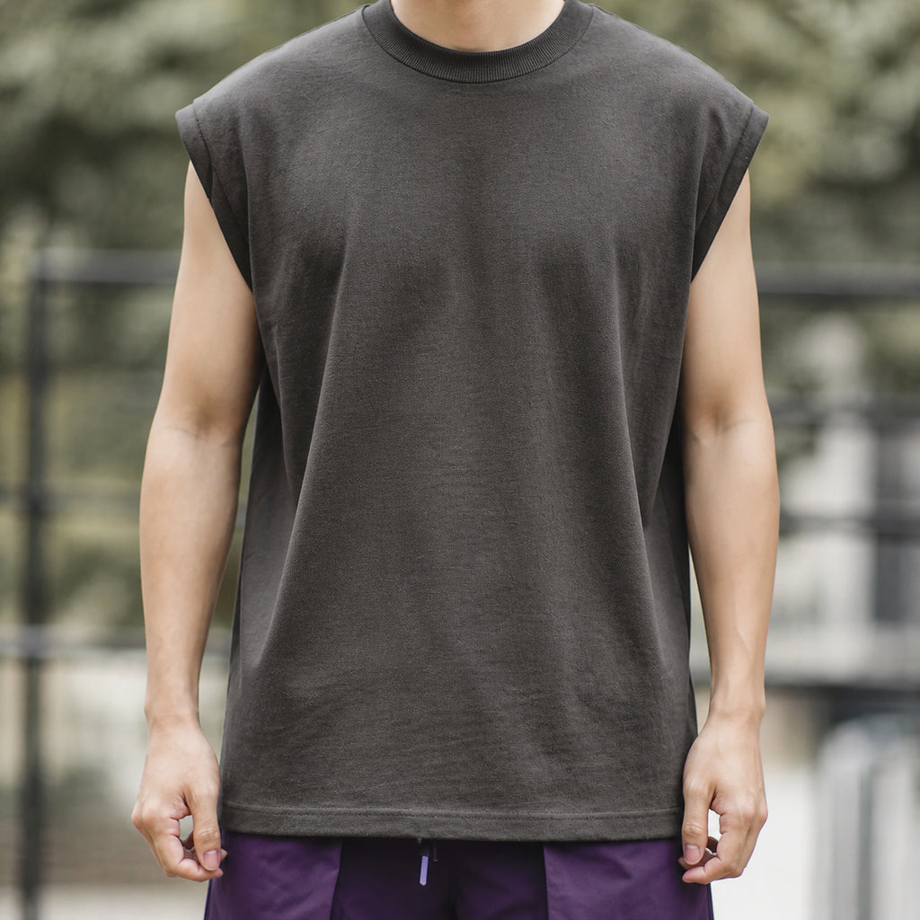 Man wearing the dark grey knit shoulder vest, front view