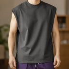 Man wearing the dark grey knit shoulder vest with purple-tone trousers