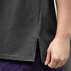 Close-up of the dark grey vest's side-slit hem