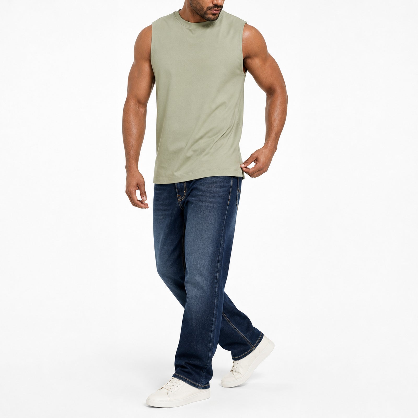 Man wearing the sage green muscle tank with blue jeans, full view