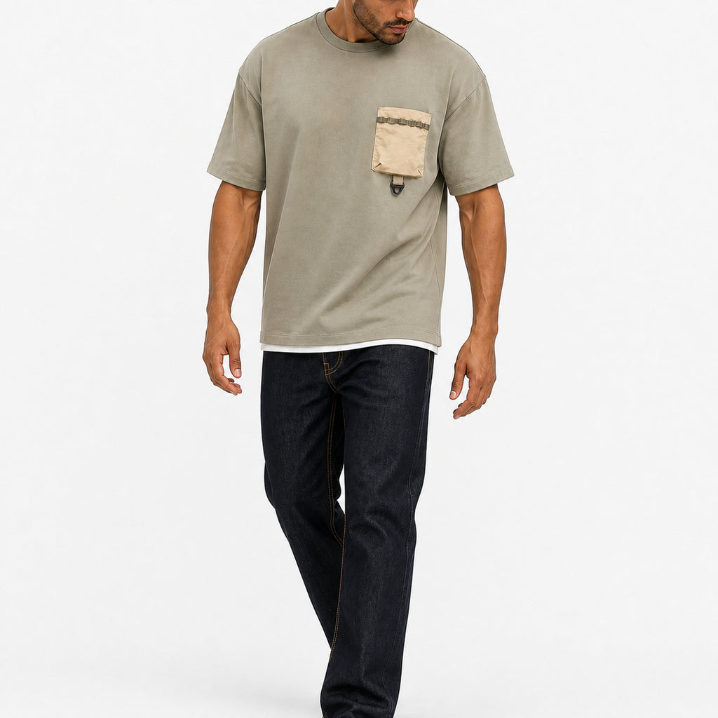 Man wearing the sage green utility tee with dark jeans, full view