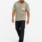 Man wearing the sage green utility tee with dark jeans, full view
