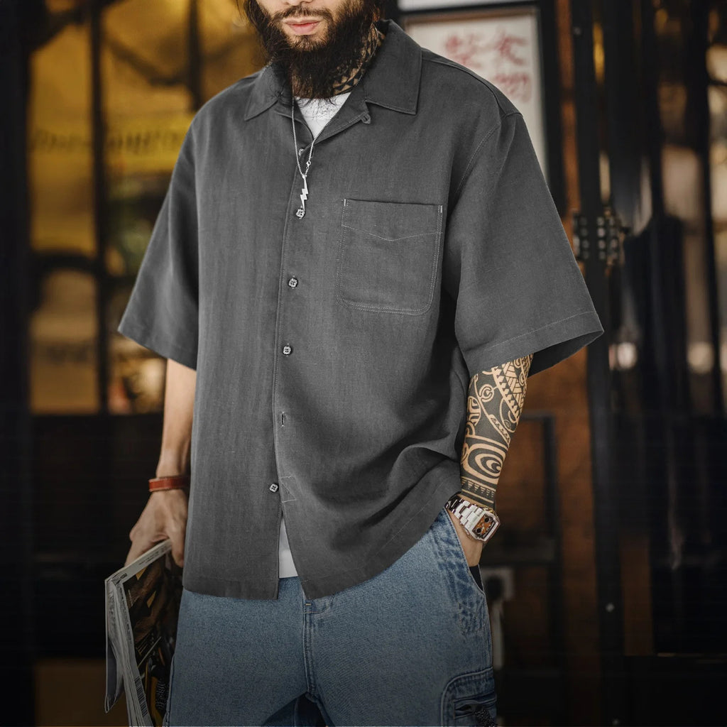 Man wearing the grey lyocell camp shirt open over a tee, street scene