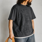 Man in the gray chief portrait tee with wide jeans, side view