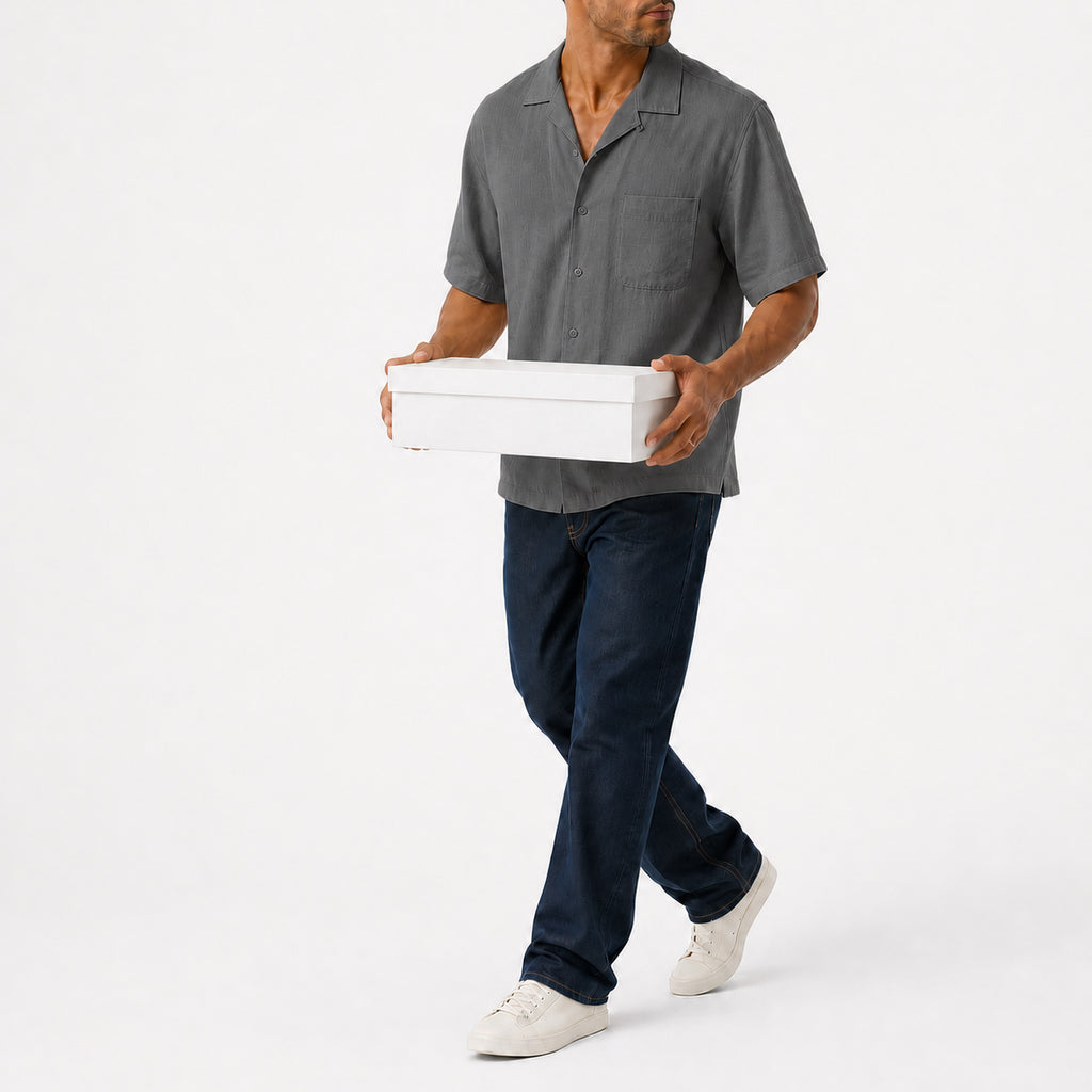 Man wearing the grey lyocell camp shirt with navy trousers, full view