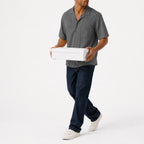 Man wearing the grey lyocell camp shirt with navy trousers, full view