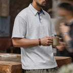 Man holding a mug in the heather grey retro polo