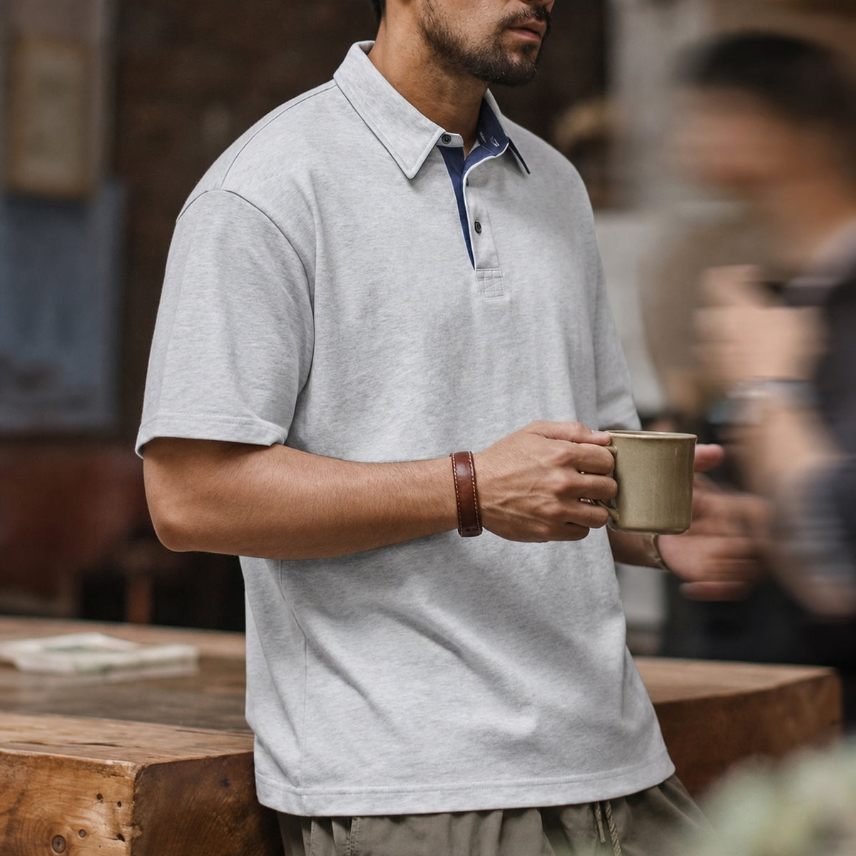 Man holding a mug in the heather grey retro polo
