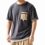 Man wearing the washed charcoal utility tee with contrast pocket and beige trousers
