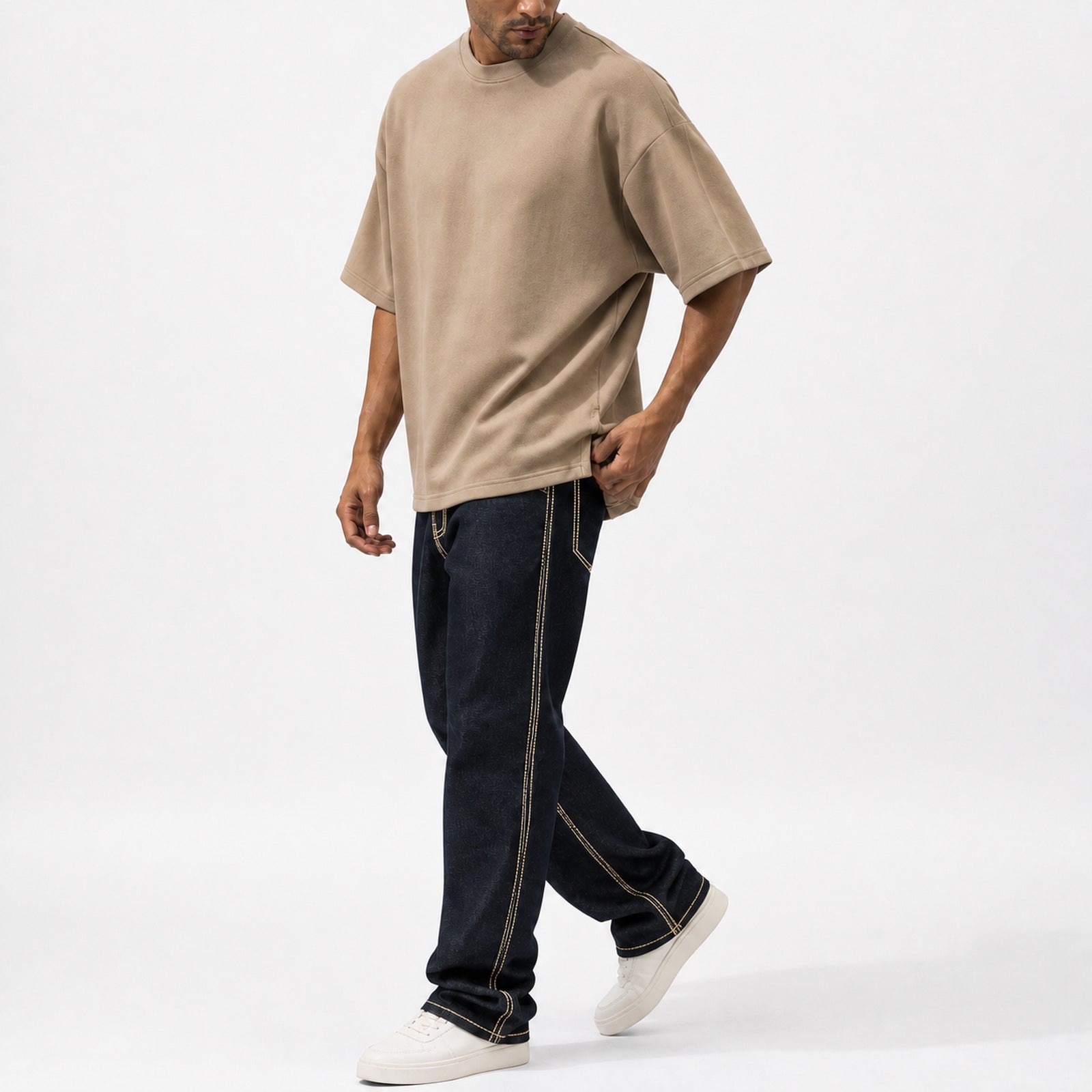 Man wearing the khaki oversized boxy tee with black trousers, full view