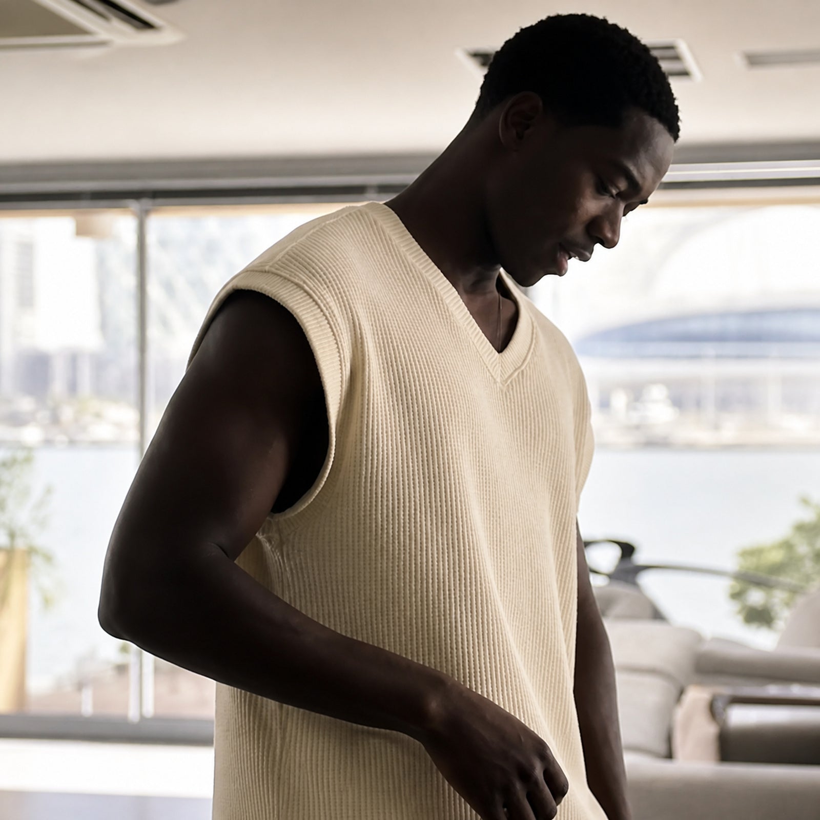 Man wearing the khaki ribbed v-neck tank, rib texture visible