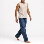 Man walking in the khaki ribbed v-neck tank with jeans, full view