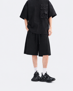 Black oversized snap-pocket T-shirt and wide-leg shorts set, front view