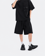 Black oversized snap-pocket T-shirt and wide-leg shorts set, angled pose