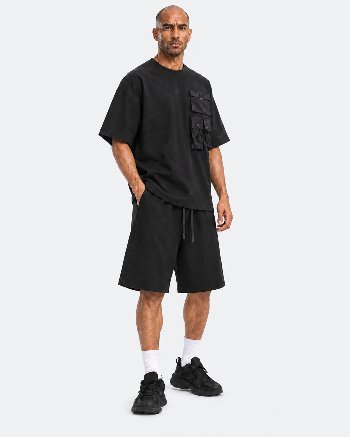 Kuwaiti model wearing the black oversized T-shirt and wide-leg shorts set, three-quarter view