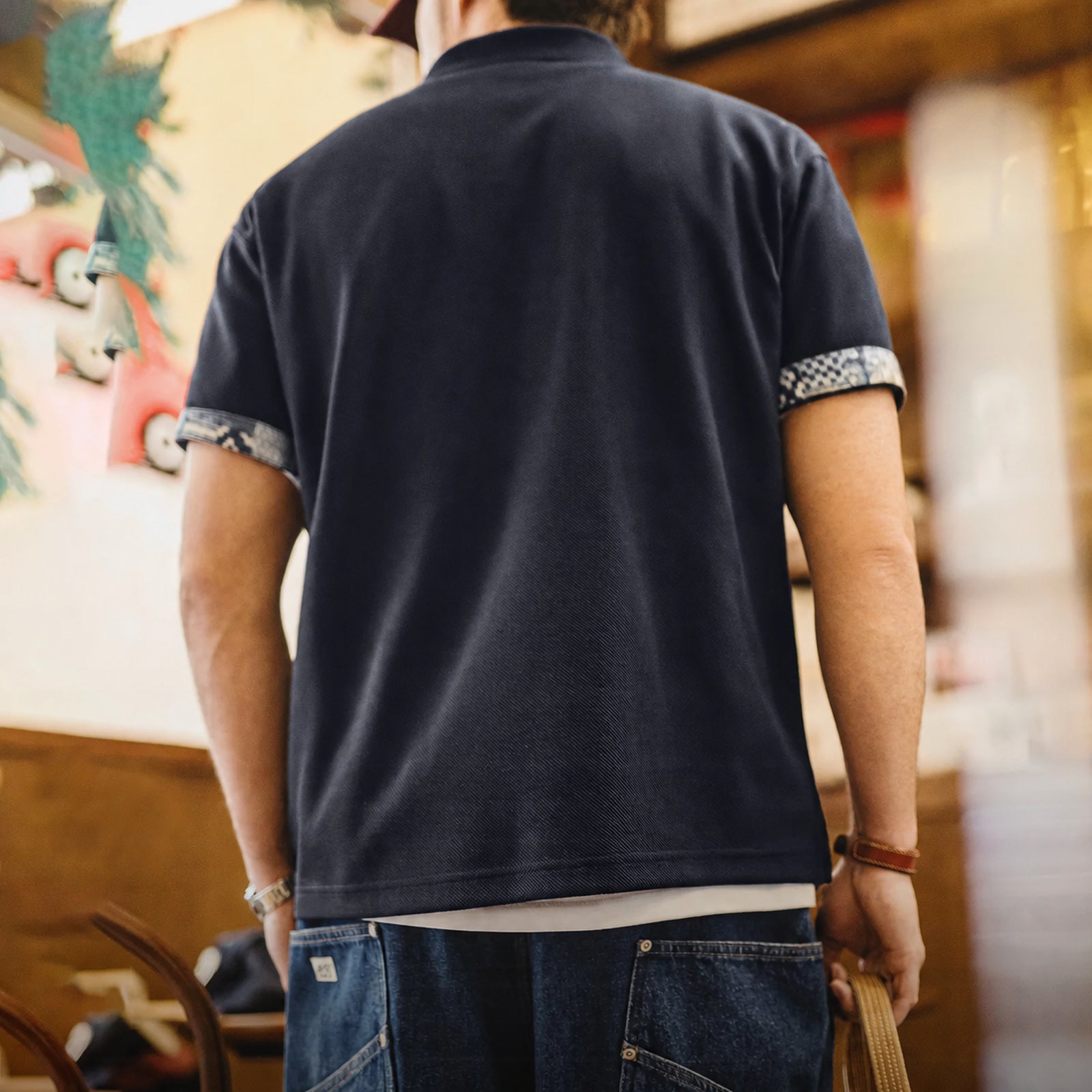 Back view of the navy polo with patterned cuff panels
