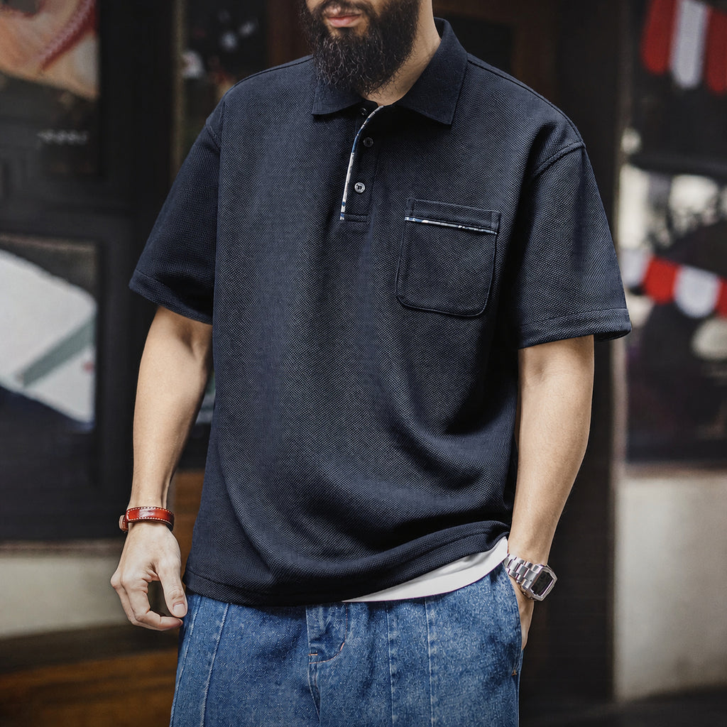 Man wearing the navy pocket polo with denim shorts