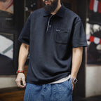 Man wearing the navy pocket polo with denim shorts