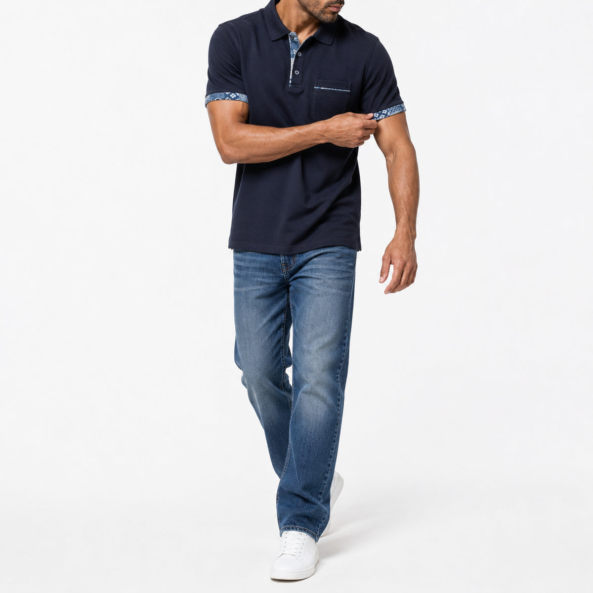 Man wearing the navy pocket polo with blue jeans, full view