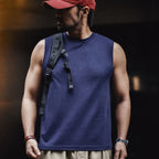 Man wearing the navy blue heavyweight tank with a backpack