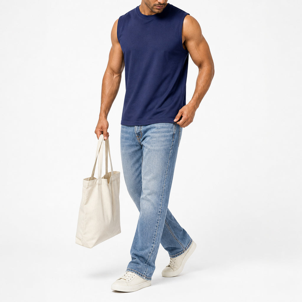 Man wearing the navy blue muscle tank with light jeans, full view