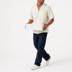 Man wearing the white lyocell camp shirt with navy trousers, full view