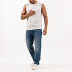 Man wearing the off-white muscle tank with blue jeans, full view