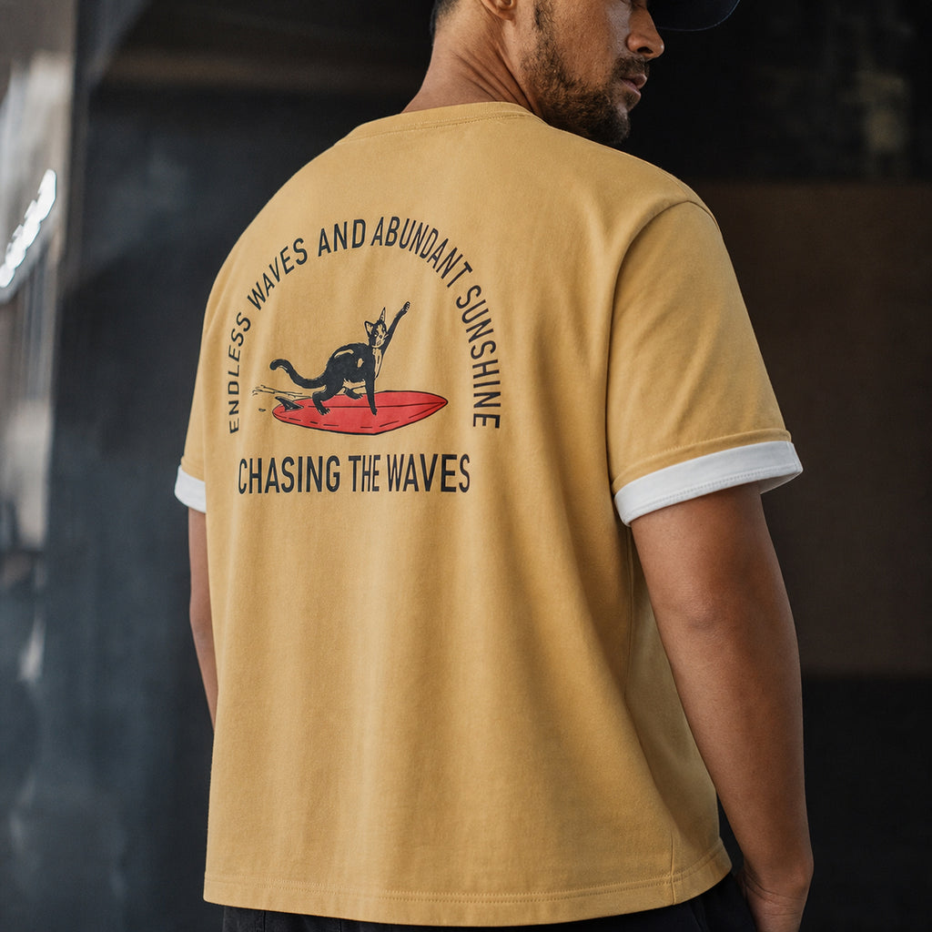 Man in the mustard surf cat tee styled over a white base tee