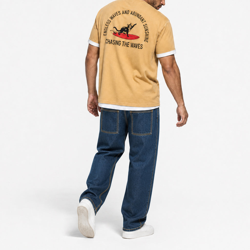 Man walking in the mustard surf cat tee with blue jeans, back view